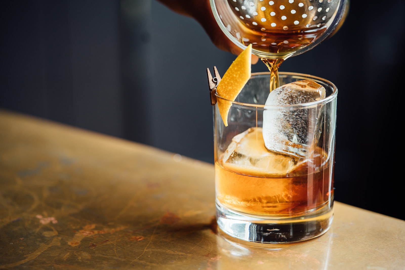 Liquor pouring on clear rocks glass